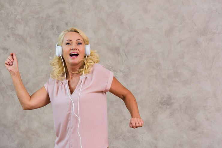 Vista frontal dama rubia escuchando música en el set de auriculares