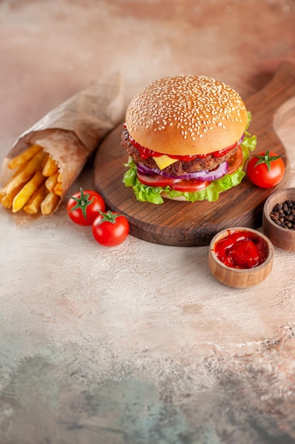 Vista frontal deliciosa carne hamburguesa con queso con papas fritas en la tabla de cortar fondo claro ensalada cena merienda comida rápida sándwich plato hamburguesa