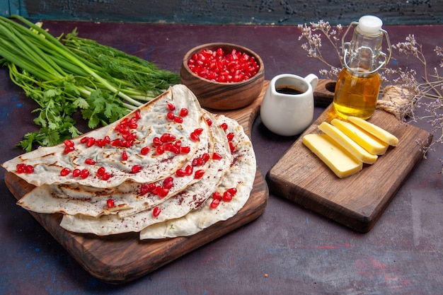 Vista frontal deliciosa carne qutabs pitas con granadas rojas frescas en la superficie oscura masa de pita comida carne