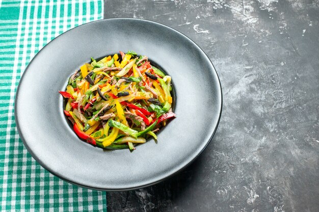 Vista frontal deliciosa ensalada de verduras dentro de la placa sobre la mesa gris