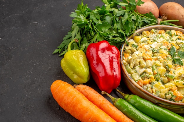 Vista frontal de una deliciosa ensalada con verduras frescas en superficie oscura