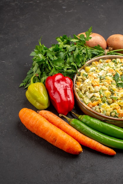 Vista frontal de una deliciosa ensalada con verduras frescas en superficie oscura