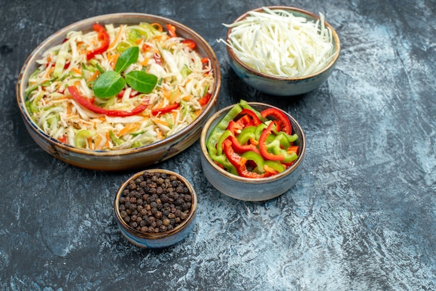 Vista frontal deliciosa ensalada de verduras con repollo y pimientos en mesa gris claro