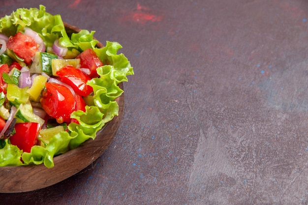 Vista frontal deliciosa ensalada de verduras en rodajas con ingredientes frescos en el espacio oscuro