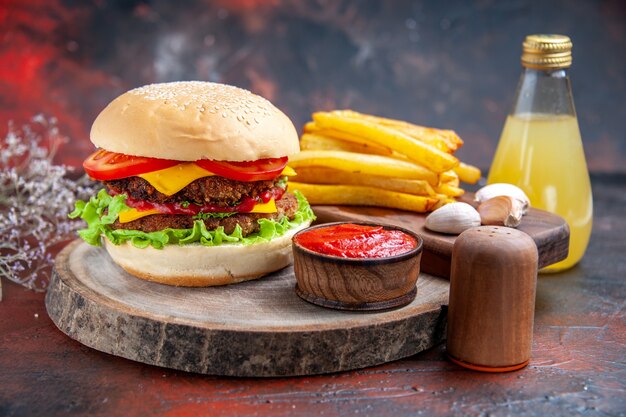 Vista frontal deliciosa hamburguesa de carne con papas fritas sobre fondo oscuro