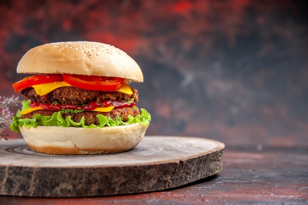 Vista frontal deliciosa hamburguesa de carne con queso sobre fondo oscuro