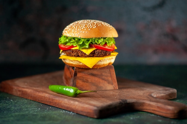 Vista frontal deliciosa hamburguesa con queso sobre fondo oscuro