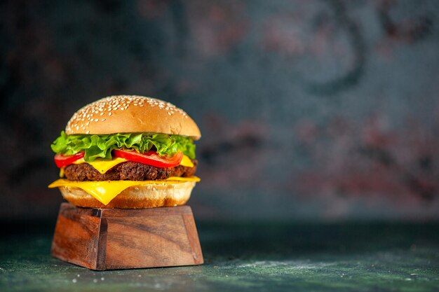 Vista frontal deliciosa hamburguesa con queso sobre fondo oscuro