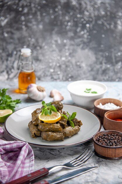 Vista frontal de la deliciosa hoja de dolma con ajo sobre superficie blanca