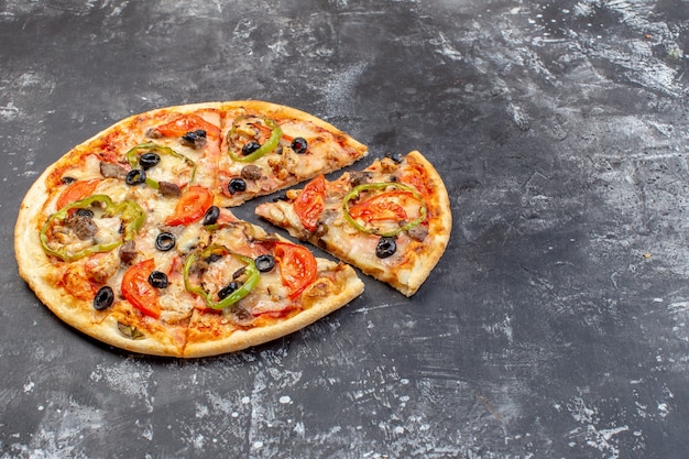 Vista frontal deliciosa pizza de queso en rodajas y servida en superficie gris