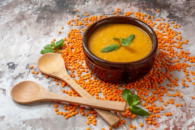 Vista frontal deliciosa sopa de lentejas con lentejas crudas