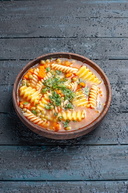 Vista frontal deliciosa sopa de pasta de pasta italiana en espiral con verduras en el escritorio oscuro plato sopa de pasta italiana salsa de cena