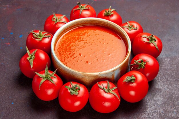 Vista frontal deliciosa sopa de tomate con tomates frescos en el espacio oscuro