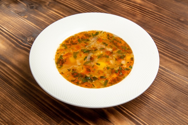 Vista frontal deliciosa sopa de verduras con verduras en la mesa de madera marrón sopa comida vegetal condimento de alimentos