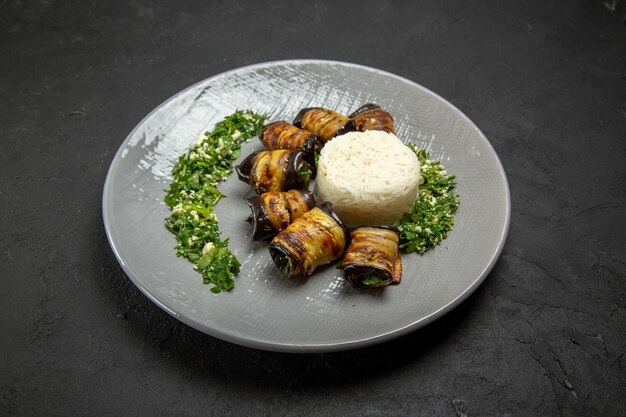 Vista frontal deliciosas berenjenas cocidas con verduras y arroz en superficie oscura cena comida aceite de cocina harina de arroz