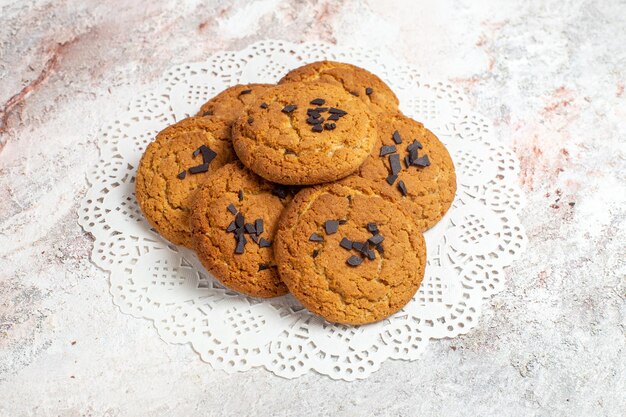 Vista frontal de deliciosas galletas de arena dulces perfectos para una taza de té en la superficie blanca