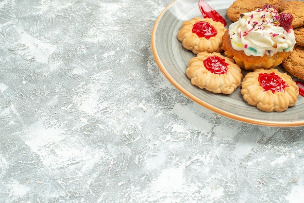 Vista frontal deliciosas galletas de arena con galletas y pastel de crema en el espacio en blanco