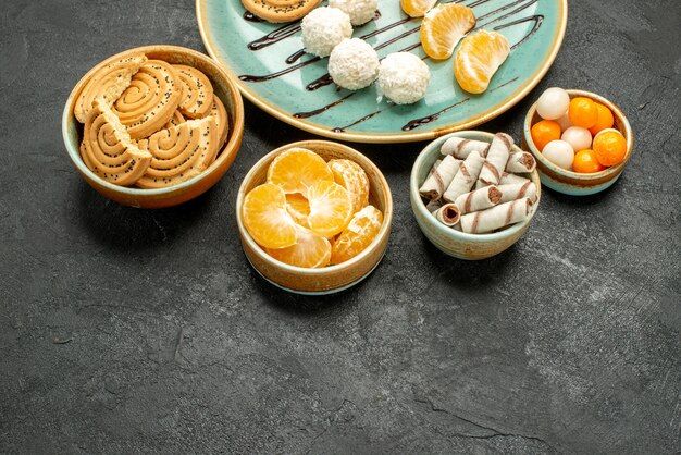 Vista frontal deliciosas galletas de azúcar con caramelos en el pastel de galletas de galletas de escritorio gris