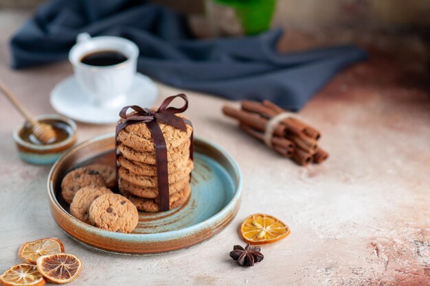 Vista frontal deliciosas galletas dulces atadas con lazo en superficie ligera postre dulce pastel de azúcar té galleta de masa horizontal