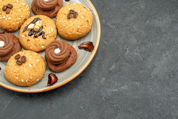 Vista frontal deliciosas galletas dulces deliciosos dulces para té en el espacio gris