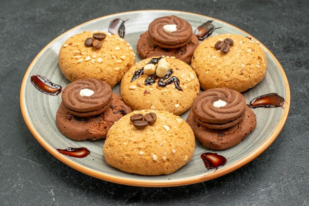 Vista frontal deliciosas galletas dulces deliciosos dulces para té en el espacio gris