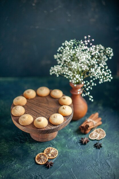 Vista frontal deliciosas galletas dulces en superficie azul