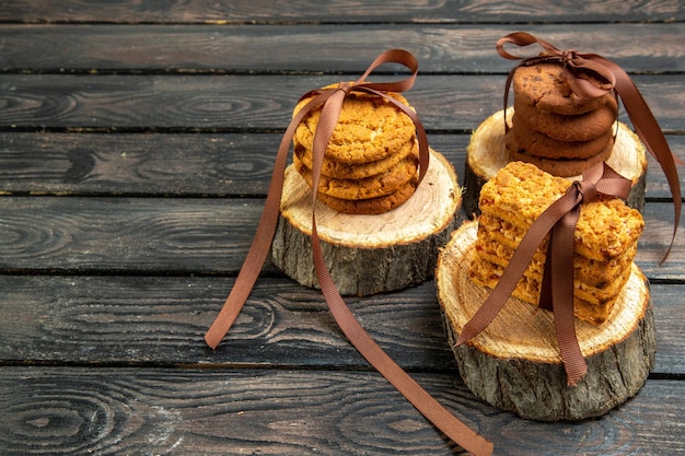 Vista frontal deliciosas galletas con galletas sobre fondo oscuro amante vacaciones corazón madera amor matrimonio nota de galleta