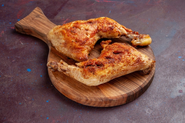 Vista frontal deliciosas rebanadas de carne cocida de pollo frito en el espacio oscuro