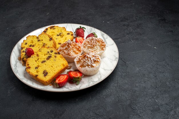 Vista frontal deliciosas rebanadas de pastel con fresas rojas frescas y galletas en superficie gris pastel hornear galletas de azúcar dulce pastel de galletas