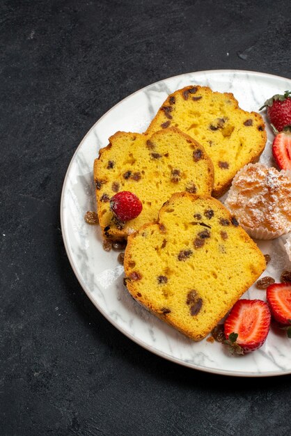 Vista frontal deliciosas rebanadas de pastel con fresas rojas frescas y galletas en la superficie gris pastel hornear pastel de galletas azúcar dulce galleta