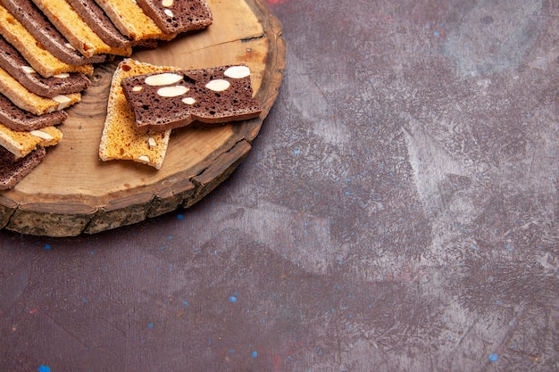 Vista frontal deliciosas rebanadas de pastel con nueces en el espacio oscuro