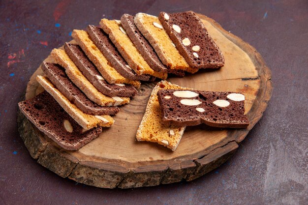 Vista frontal deliciosas rebanadas de pastel con nueces en el espacio oscuro