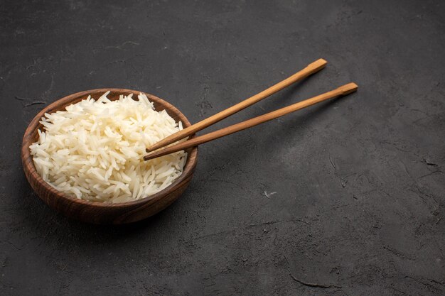 Vista frontal delicioso arroz cocido sabrosa comida oriental en el espacio oscuro