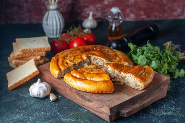 Vista frontal delicioso pastel de carne con verduras y tomates sobre fondo oscuro pastel de galletas pasteles de comida horno de pastelería hornear masa color