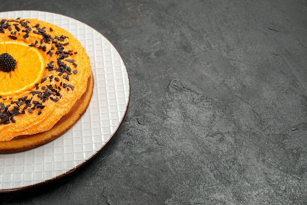 Vista frontal delicioso pastel con chispas de chocolate y rodajas de naranja sobre fondo oscuro pastel de té pastel de postre galleta de frutas