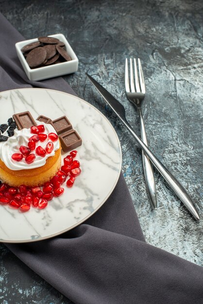 Vista frontal delicioso pastel cremoso con chocolate y pasas sobre un fondo claro-oscuro galleta galleta dulce postre azúcar