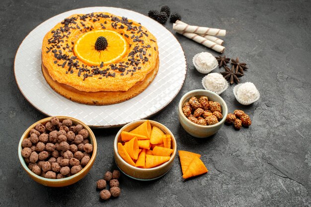 Vista frontal delicioso pastel dulce con rodajas de naranja sobre fondo gris oscuro masa pastel pastel de frutas galleta