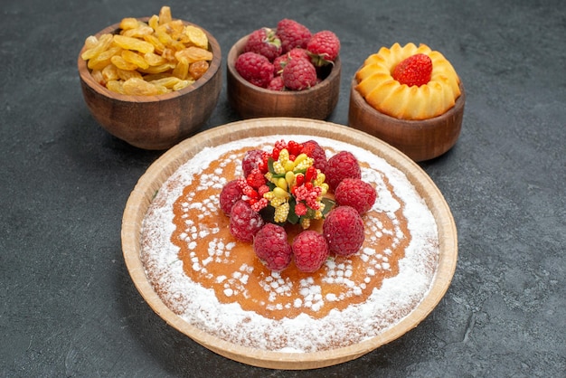 Foto gratuita vista frontal delicioso pastel de frambuesa con pasas sobre fondo gris pastel de galleta de té de azúcar galleta pastel dulce