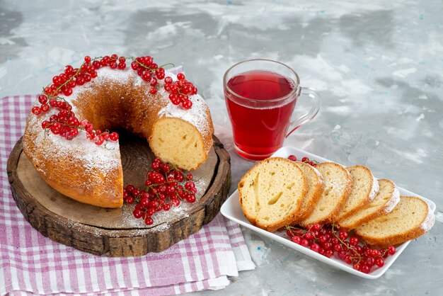 Una vista frontal delicioso pastel redondo con arándanos rojos frescos y jugo de arándano en el escritorio blanco pastel galleta té baya azúcar