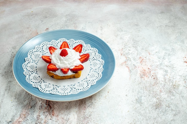 Foto gratuita vista frontal delicioso pastelito con crema y fresas en el escritorio blanco