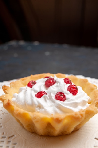 Vista frontal delicioso pastelito con crema y frutas en la superficie oscura fruta dulce