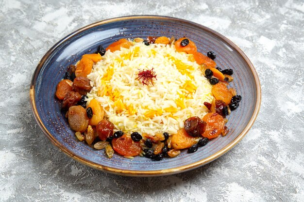 Vista frontal delicioso plato de arroz cocido shakh plov con pasas dentro de la placa en el espacio en blanco