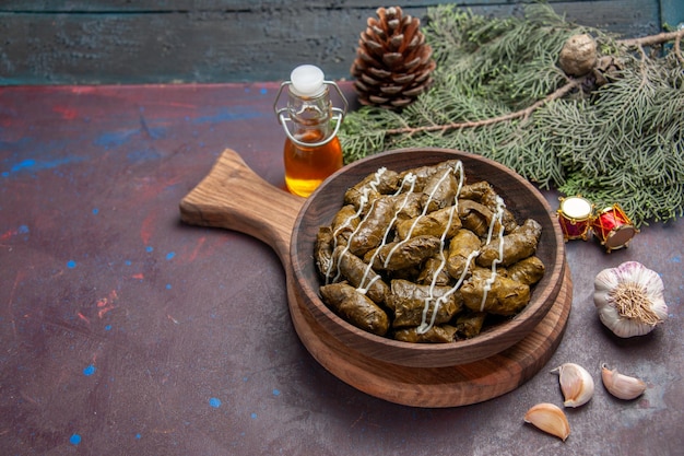 Vista frontal del delicioso plato de carne de dolma de hoja con condimentos en el espacio oscuro