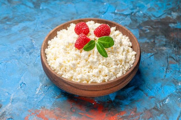 Foto gratuita vista frontal delicioso requesón con frambuesas frescas sobre fondo azul salud baya blanca foto color de la fruta de la leche