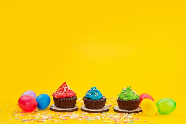 Vista frontal de deliciosos brownies a base de chocolate junto con caramelos en amarillo, color de galleta de pastel de caramelo