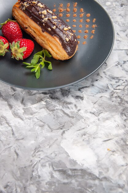 Vista frontal deliciosos canutillos de chocolate con fresas en el piso de luz postre pastel de caramelo