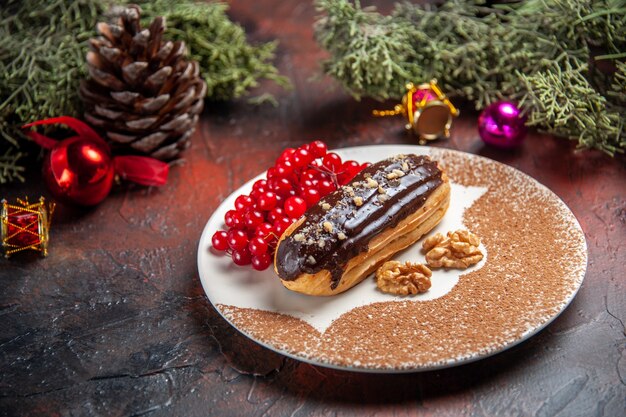 Vista frontal deliciosos canutillos de chocolate con frutos rojos sobre fondo oscuro