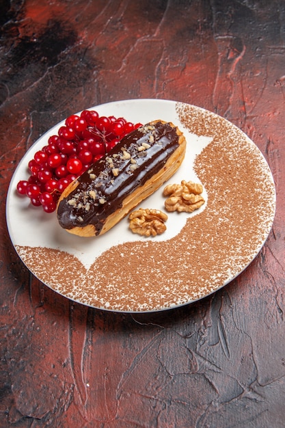 Vista frontal deliciosos canutillos de chocolate con frutos rojos sobre fondo oscuro