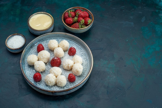 Vista frontal de deliciosos caramelos de coco con fresas