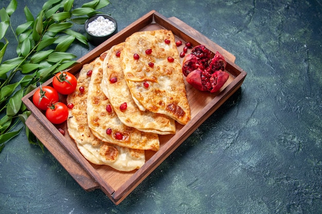 Vista frontal deliciosos hotcakes delgados gutabs con carne dentro del escritorio sobre una superficie oscura